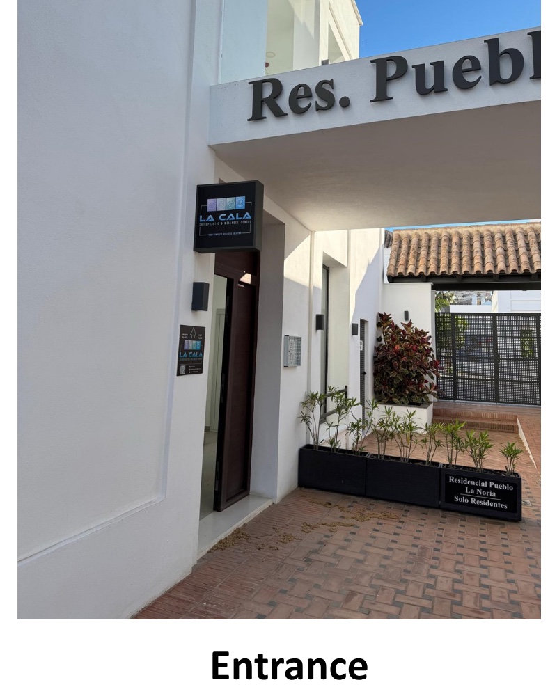 The entrance to the building, beside the Residencial Pueblo La Noria sign.